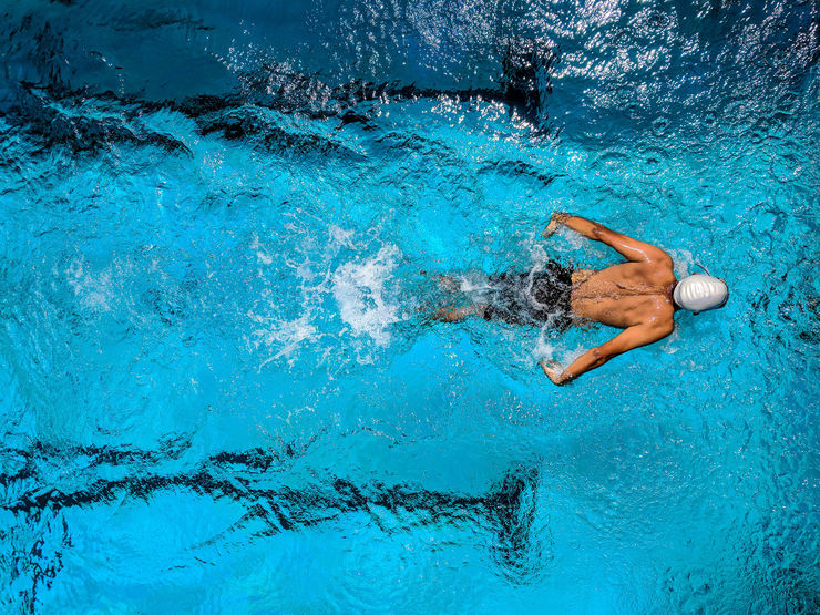 Elite athlete swims in a pool.