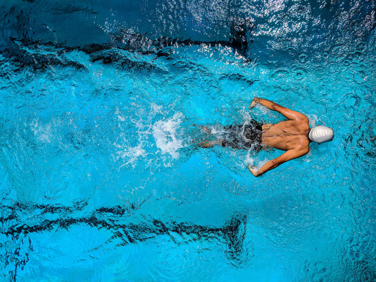 Elite athlete swims in a pool.