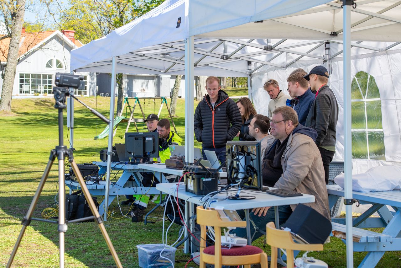 Flera personer samt teknisk utrustning i ett partytält