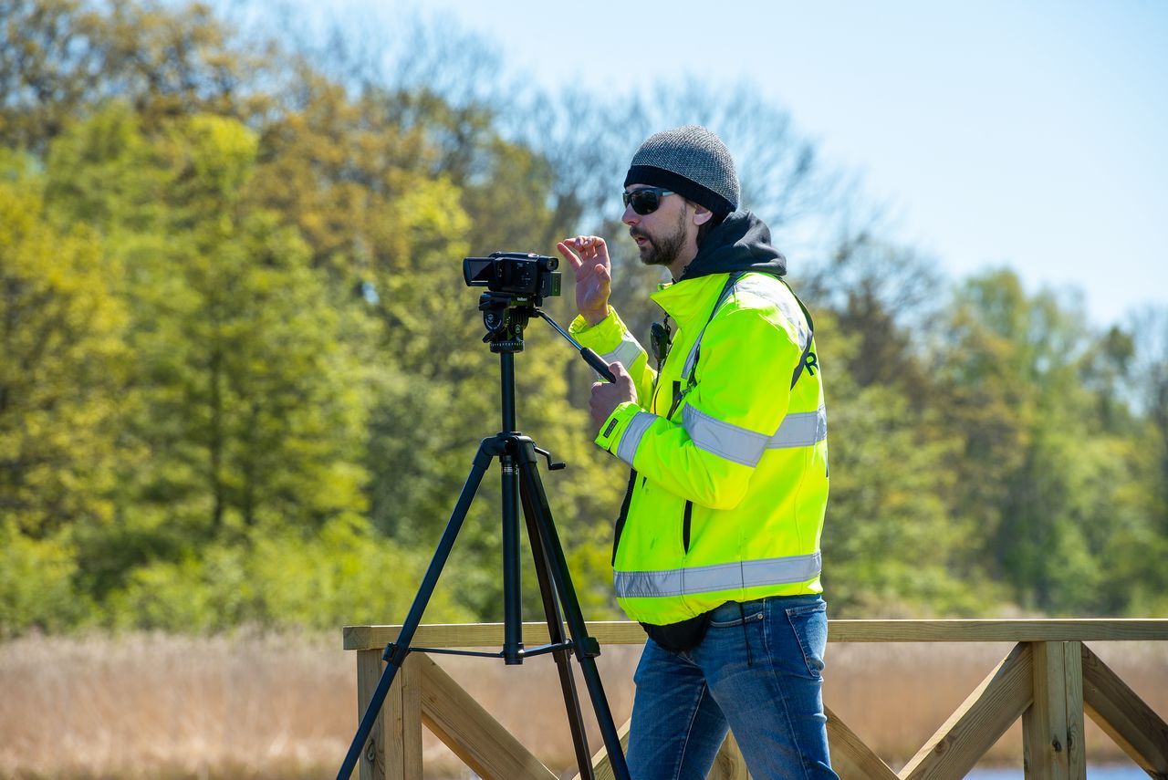 En man med en filmkamera på stativ.