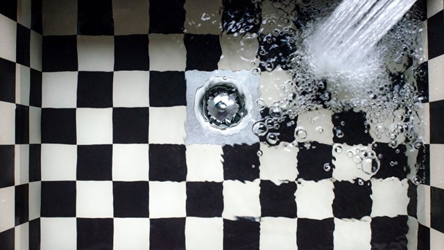Vatten som spolar ut från en kran ner i ett handfat.
