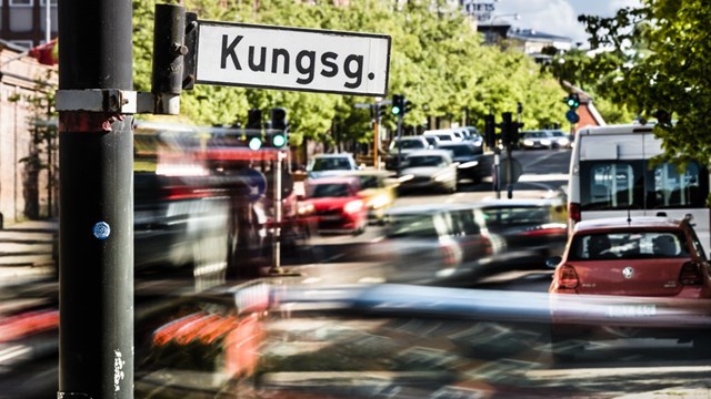 På en vägskylt står det "Kungsgatan". I bakgrunden syns trafik i rörelseoskärpa.