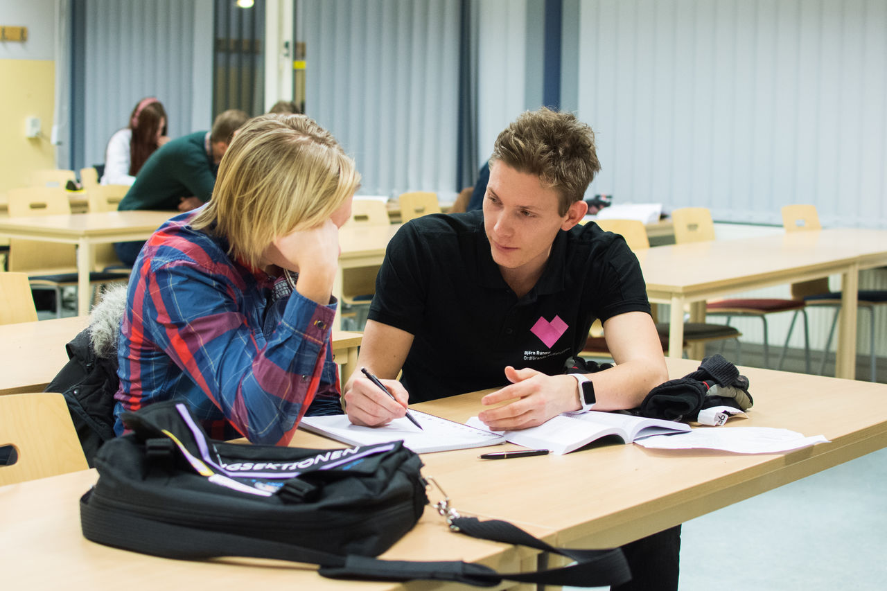 Student hjälper elev i skolbänk