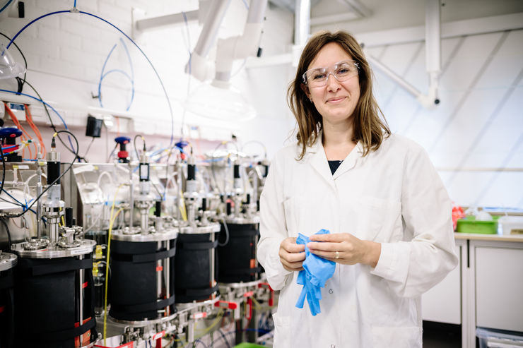 Eva-Maria Ekstrand tar på sig handskar i laboratoriet