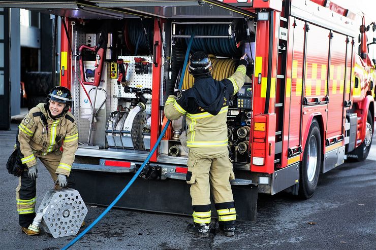 Brandmän vid brandbil.