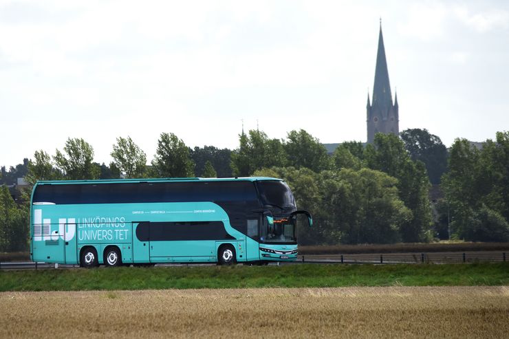 En bus i turkos färg med Linköpings universitet logotyp