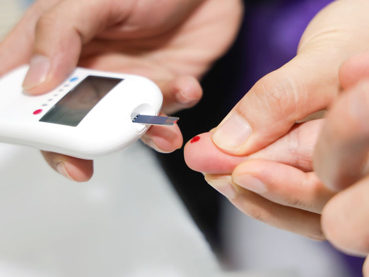 Close up of Doctor taking sample of diabetic patient's blood using lancet pen,Healthcare and Medical concept