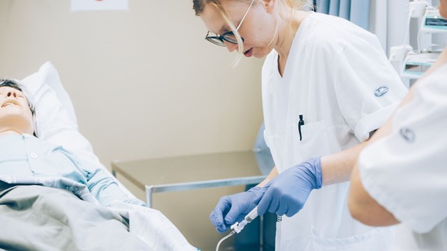 Sjuksköterskestudent övar injektion på simulatordocka