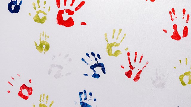 Vid ingången till Ljuraskolan har barnen fått göra avtryck av sina händer i olika färger. De sitter som en dekoration på väggen.