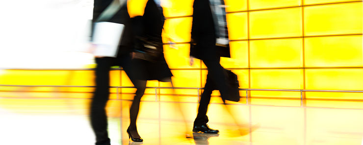 Abstract image with walking people - bright yellow wall