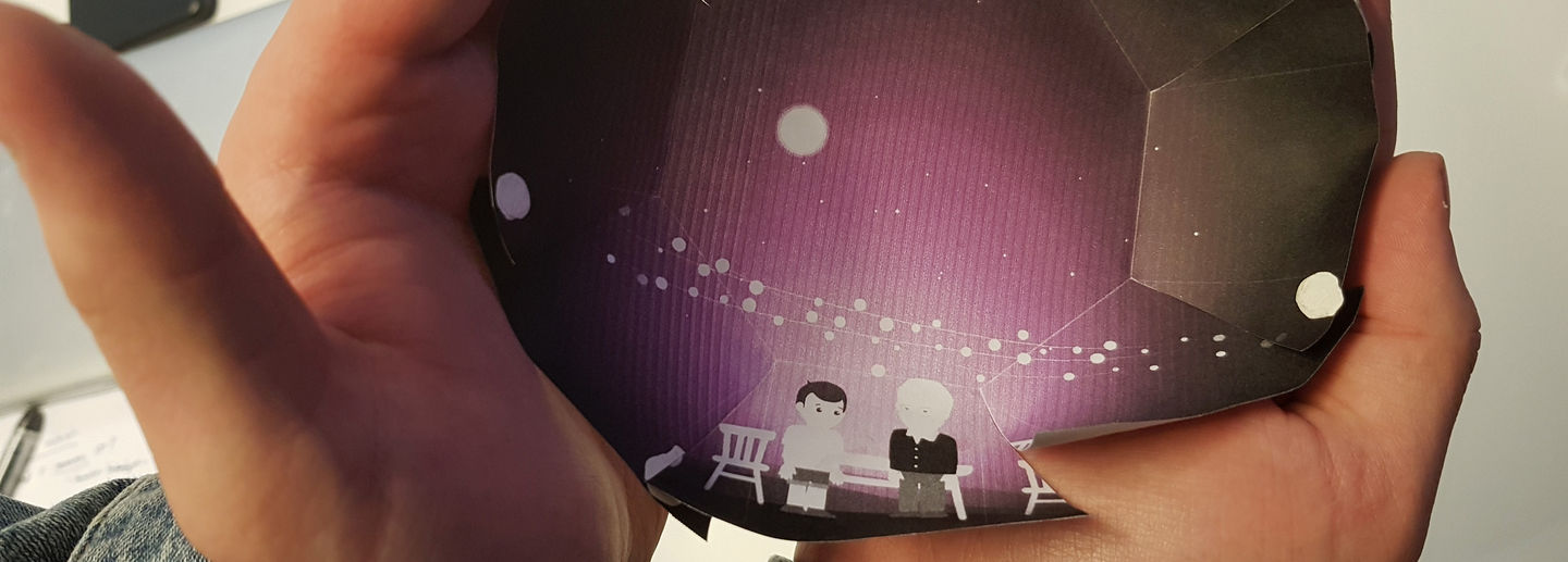 A hand holds a picture of two people.