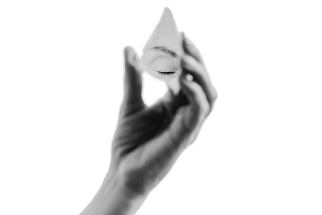 Hand som håller en spegelskärva som visar ett öga