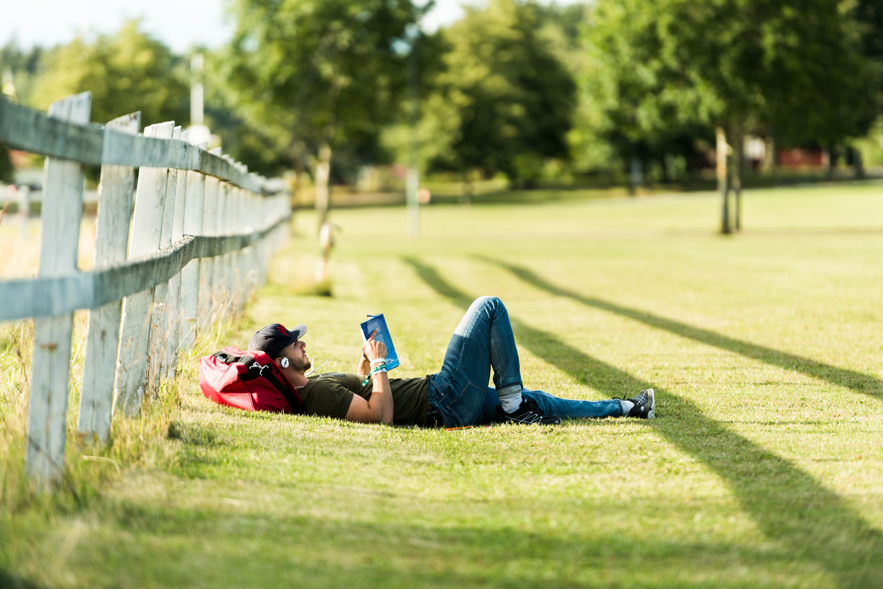 Student laying in the grass reading