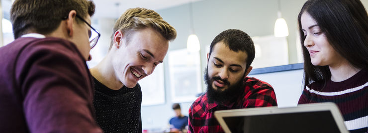 Fyra studenter diskuterar och skrattar.