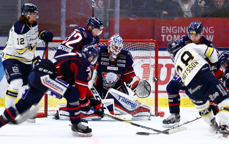 Three LHC-players and tvo from HV in front of LHC's goal and goalkeeper during a hockey game. 