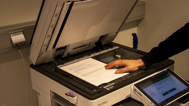 A copying machine with a paper that is being copied.