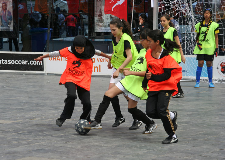 Fyra flickor spelar fotboll.