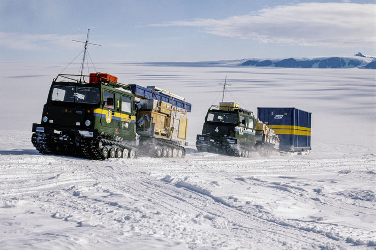 Två bandvagnar åker över isen