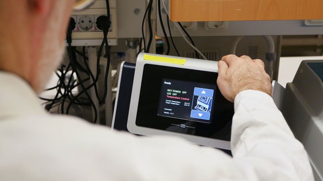 researcher points at a research instrument screen