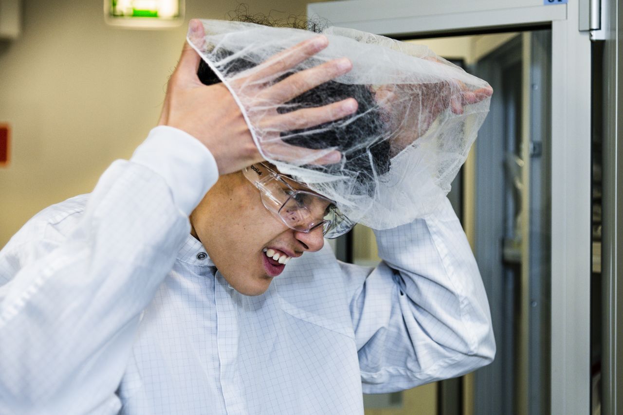 A man is putting on a hair net.