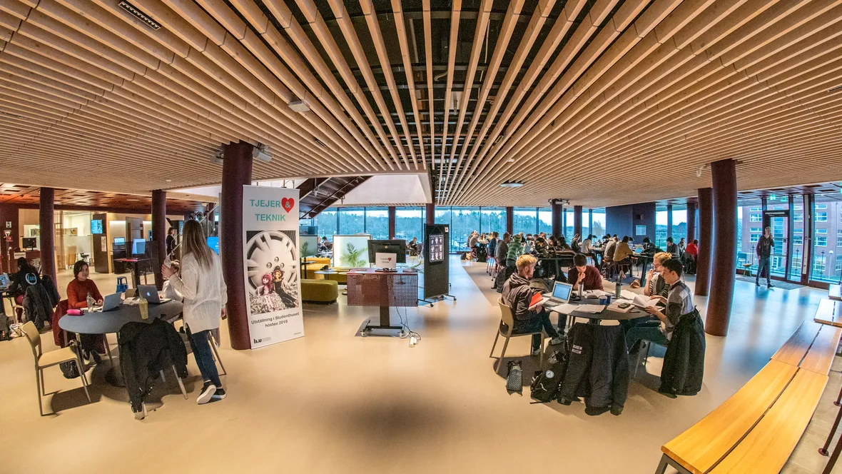 A number of tables with students  studying.