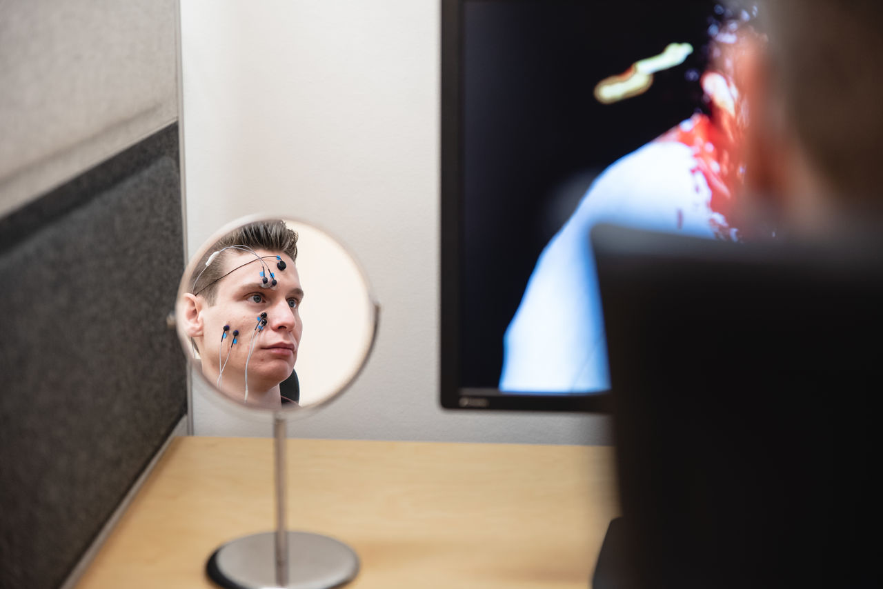 En försöksperson med elektroder fästa i ansiktet.