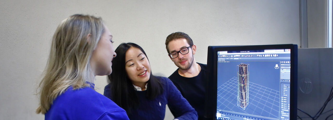 studenter vid en datorskärm som visar en 3d-modell.