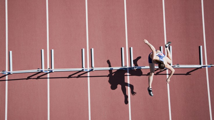 A hurdler on the hurdle course from a bird eye's view. 