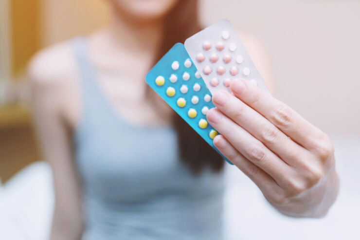 Woman hands opening birth control pills in hand. Eating Contraceptive Pill.