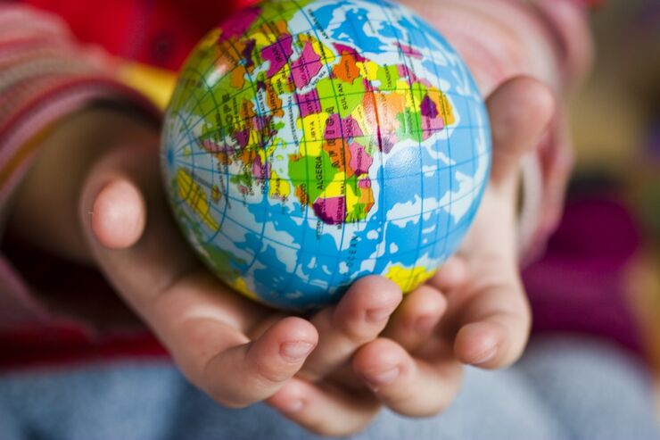 Child holding the globe in hands. 