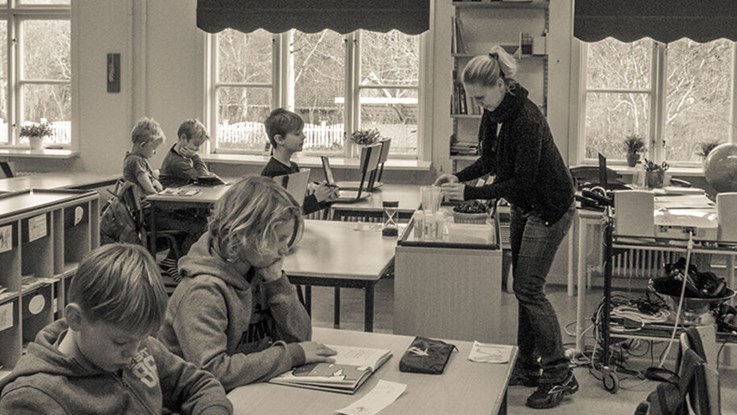 Lärare undervisar elever i ett klassrum. 