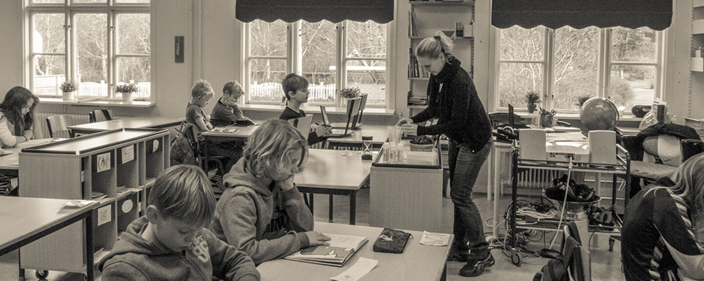 Lärare undervisar elever i ett klassrum. 