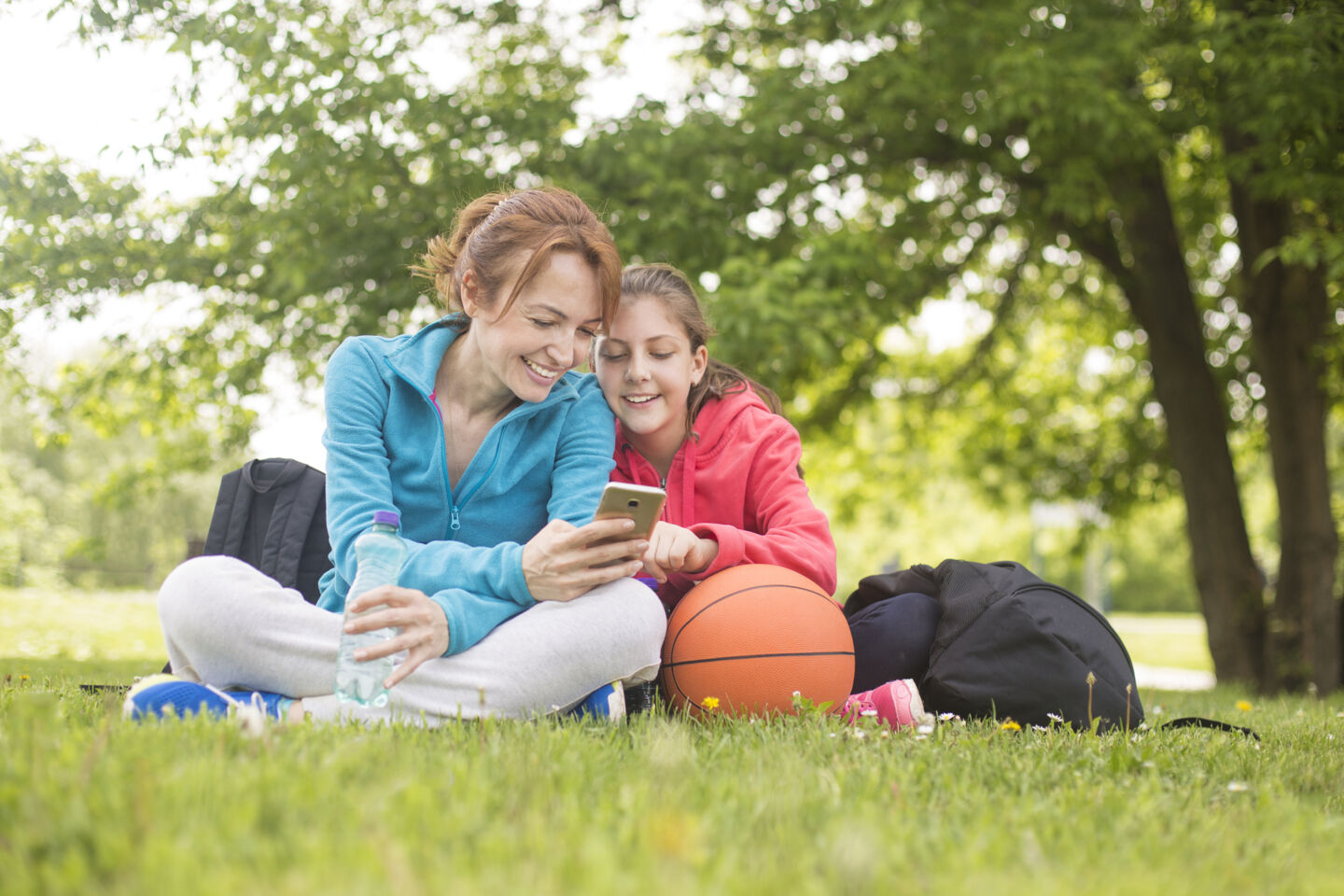 Mor och dotter tittar på en telefon