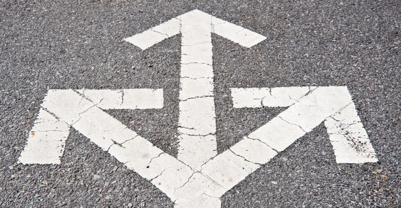 Three-way-arrows on asphalt.