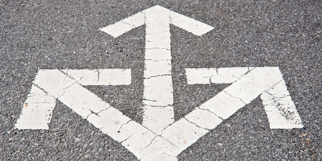Three-way-arrows on asphalt.