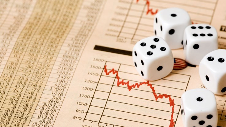 Dices lying on paper on stock market prices.
