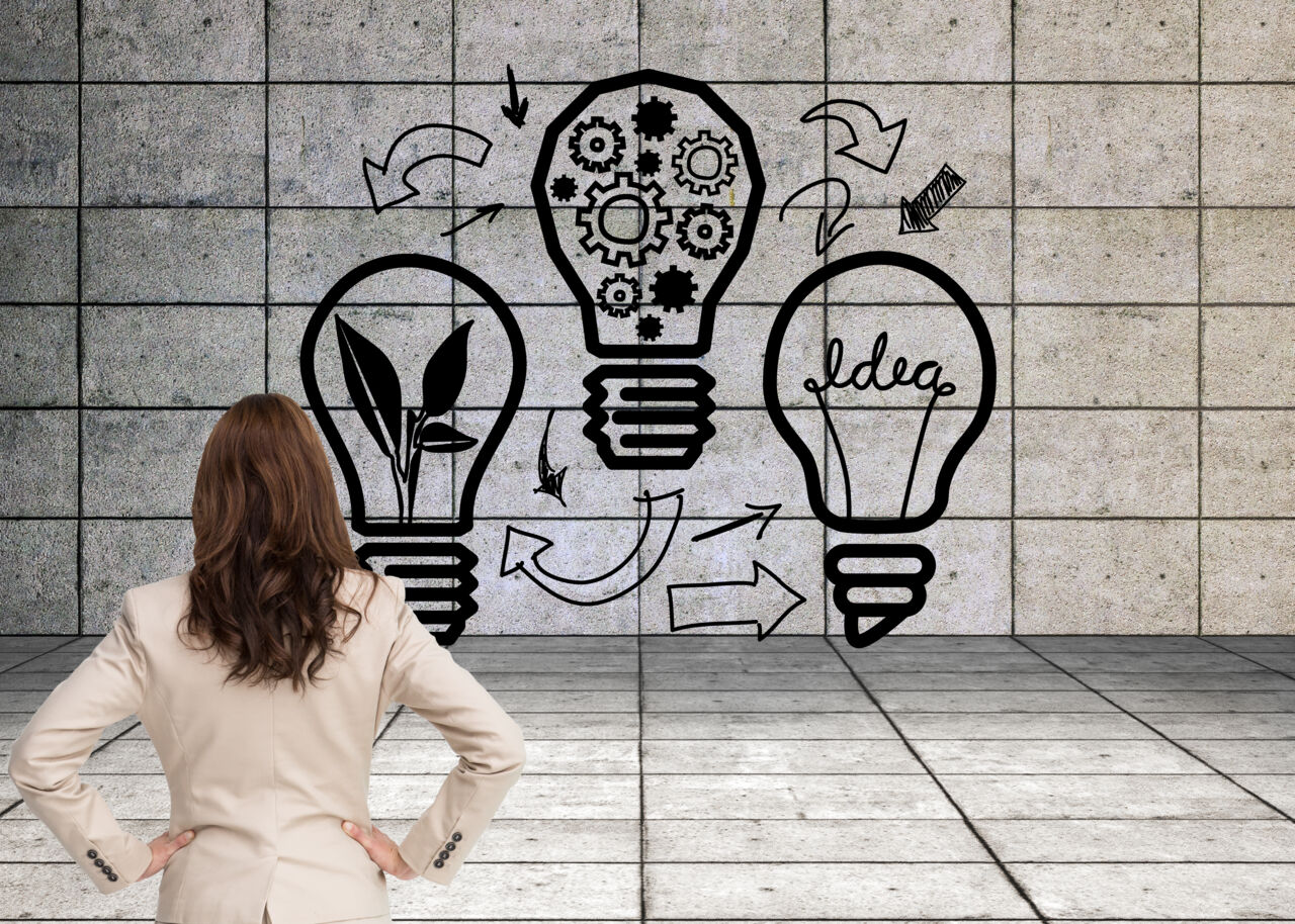 Affärskvinna står med ryggen mot kameran.