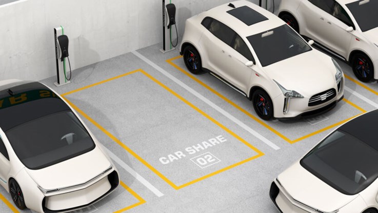 Vita elbilar på parkeringsrutor där det står "car share"