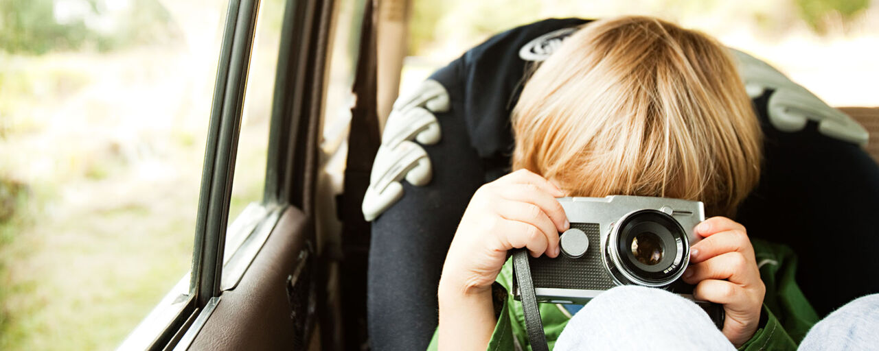 A young boy playing with a camera