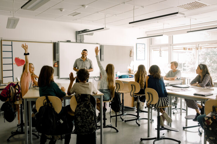 Students raise their hand when a teacher holds a lesson.