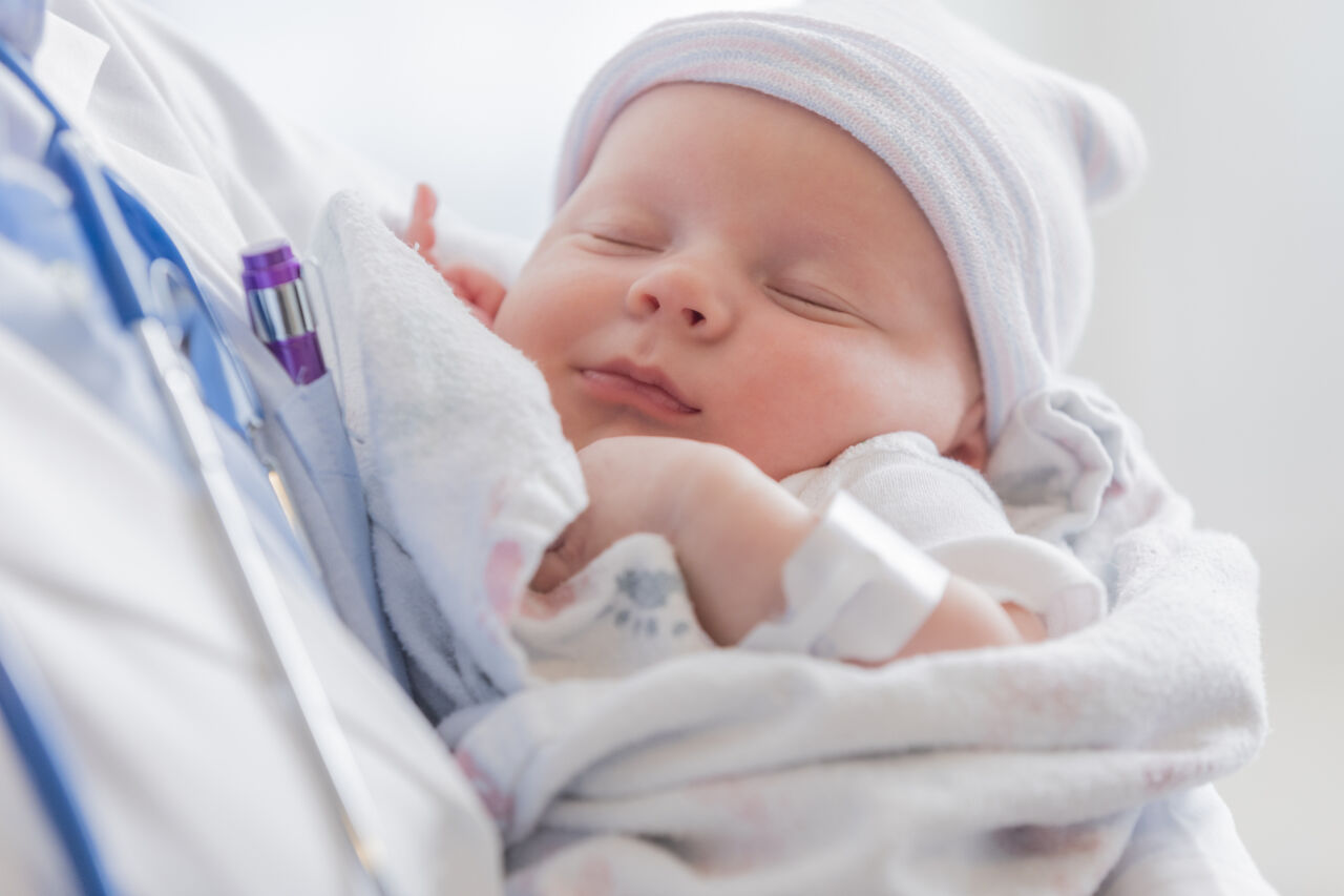 Infant in the arms of a doctor.