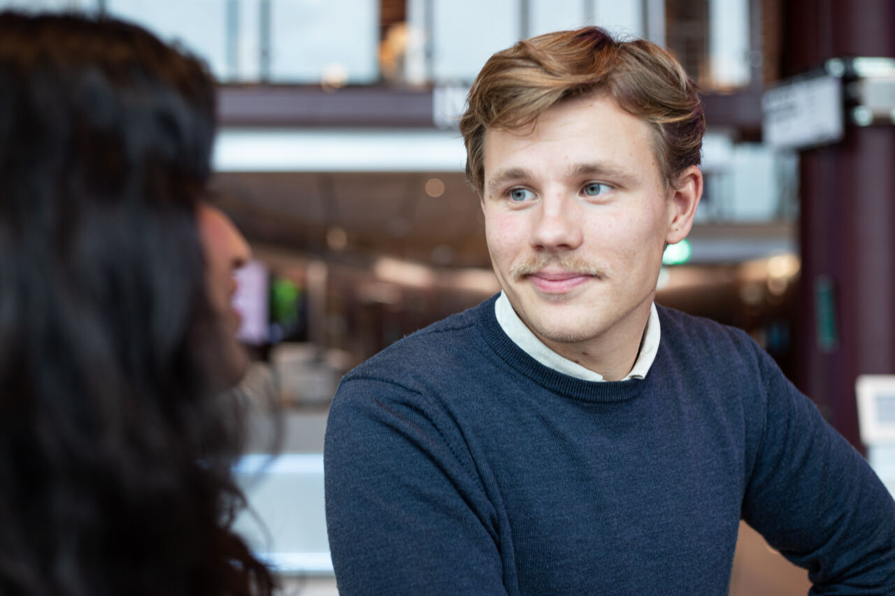 Markus Pettersson, LiU student, i samtal med Maria Lokat som bara syns lite bakifrån nere i hörnet.