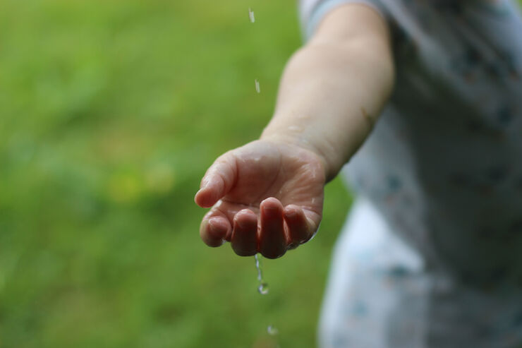 Bild på hand som tar emot regndroppar