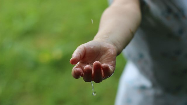 Bild på hand som tar emot regndroppar