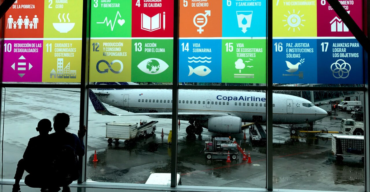 En flygplats med FN:s miljömål på fönstret ut mot flygplanen