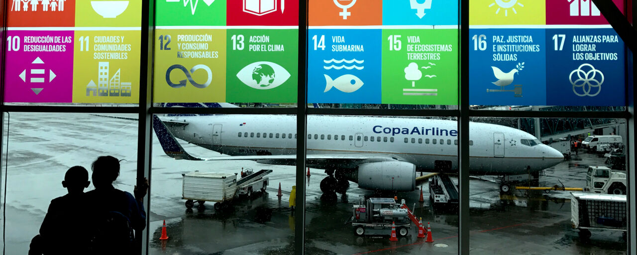 En flygplats med FN:s miljömål på fönstret ut mot flygplanen