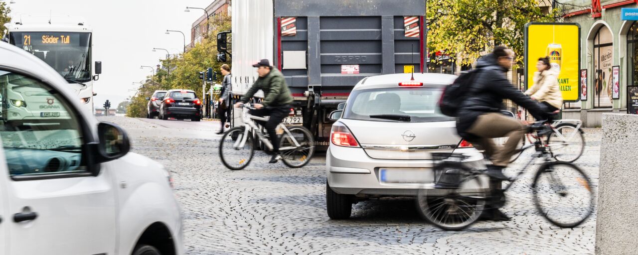 Trafik i stadsmiljö, bilar, lastbil och cyklar