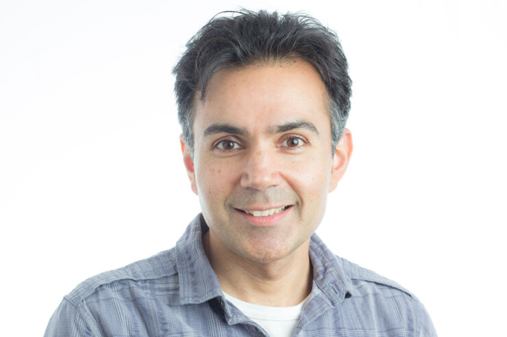 portrait photo of a man, black hair, blue shirt.