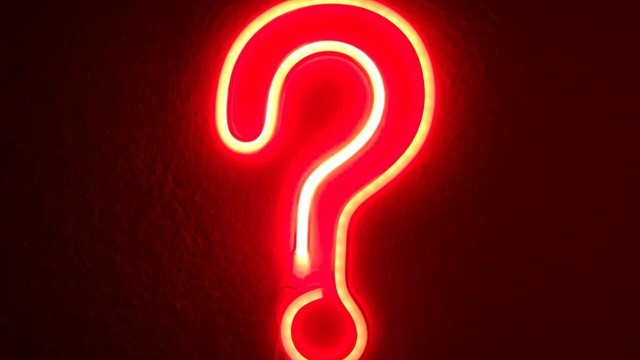 A neon sign in the shape of a question mark.