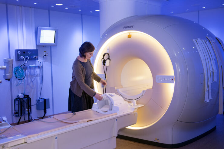 Maria Engström next to a magnetic resonance scanner.